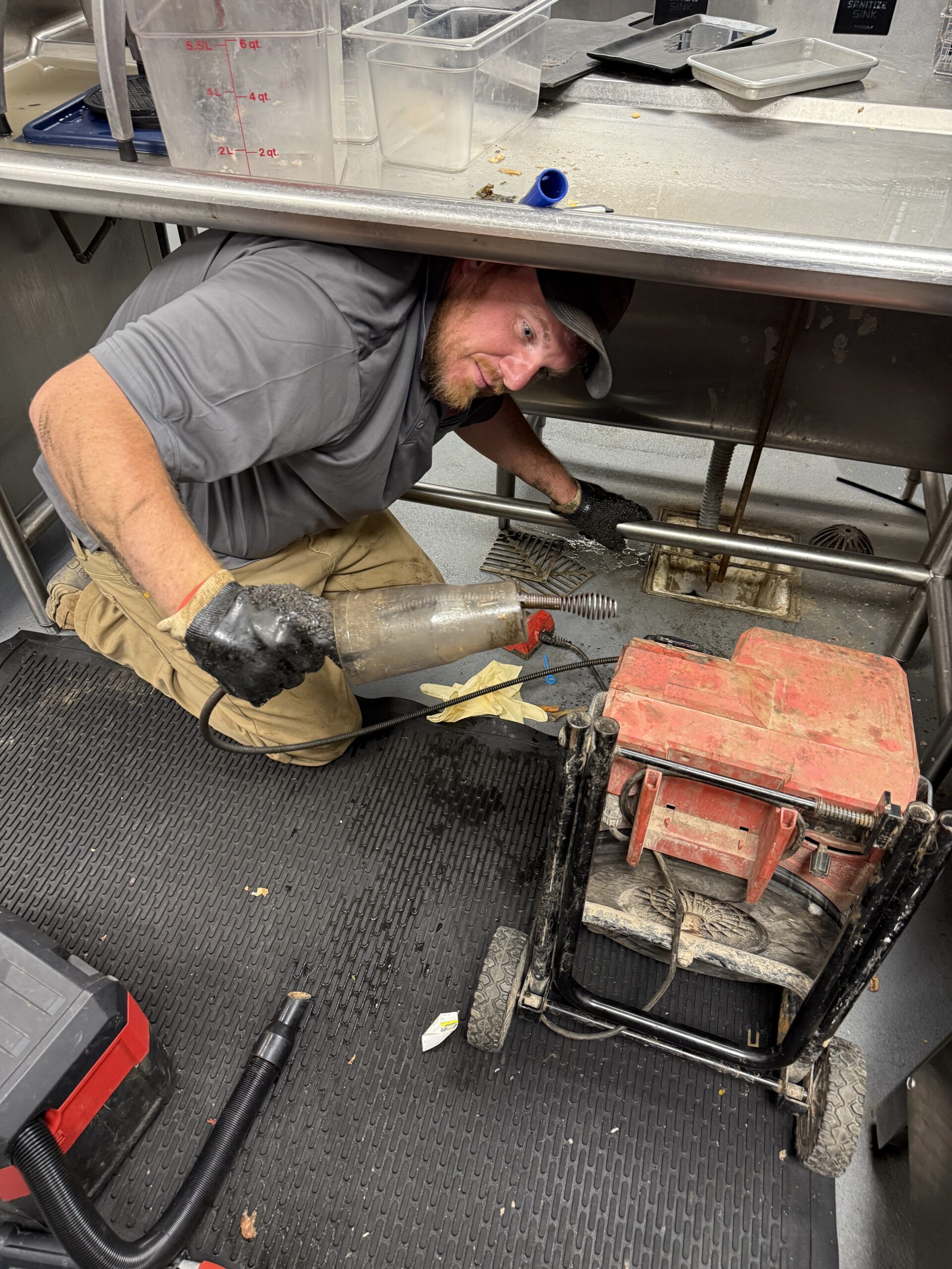 Plumber clearing commercial kitchen drain clog, Mobile AL